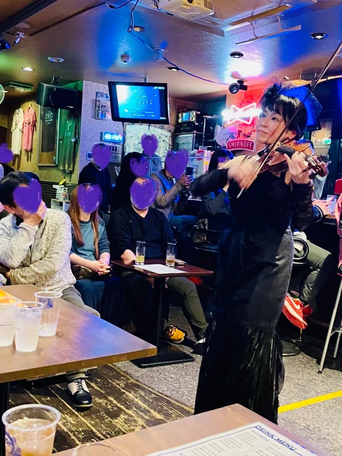 紙飾りのある店内でヴァイオリンを演奏する田中雅子
