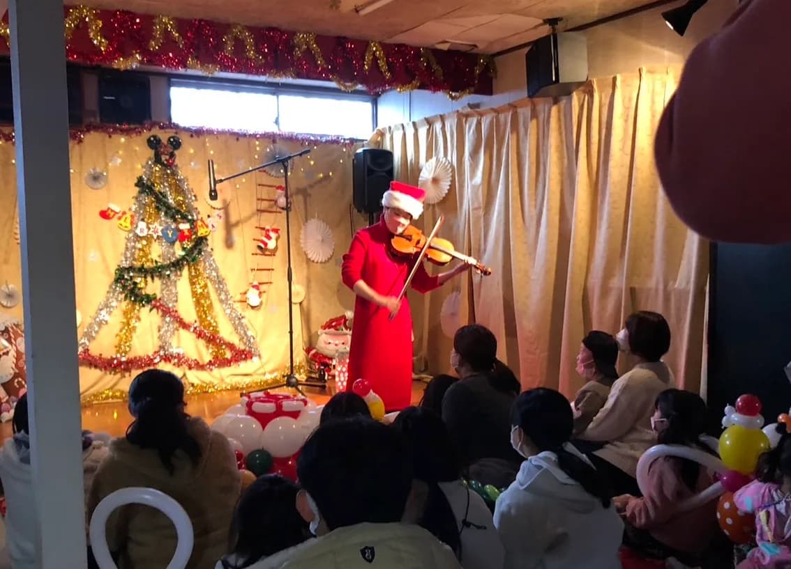 クリスマス装飾の会場でヴァイオリンを演奏する田中雅子